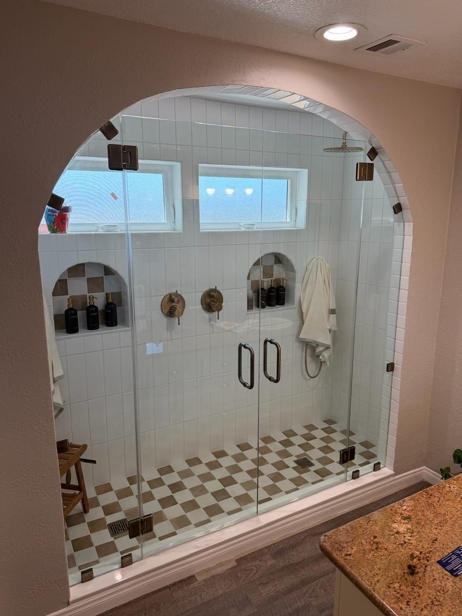 Luxury arched walk-in shower with checkerboard tile from a master bathroom remodel in Encino