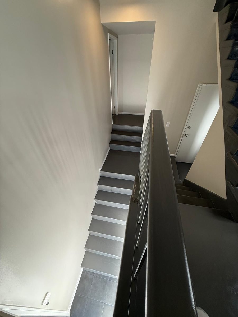 Modern floating staircase with black steel railings in a renovated Pacific Palisades home
